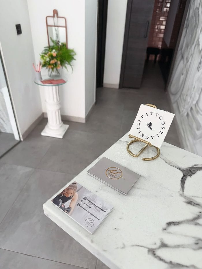 Recepción del estudio BlackLili Tattoos, con tarjetas de visita y detalles decorativos