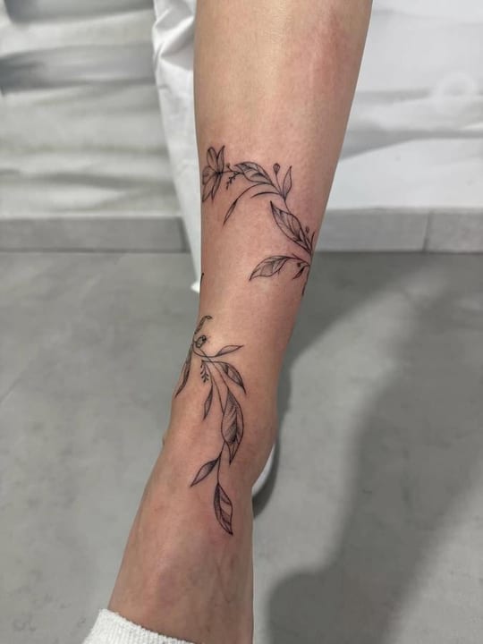 Tatuaje botánico de enredadera floral en línea fina, tobillo — Madrid