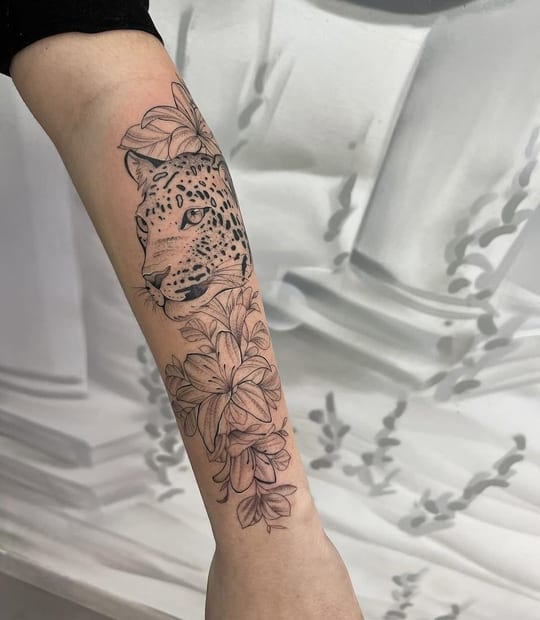 Tatuaje de leopardo con lirios en línea fina, antebrazo — Madrid