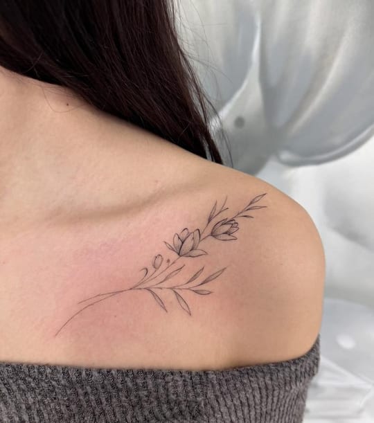 Tatuaje botánico de rama floral en línea fina, hombro — Madrid